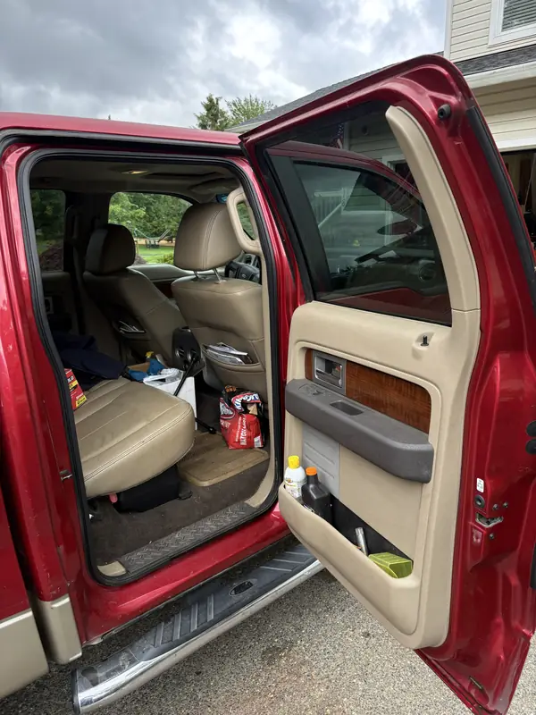 F-150 back seat before, covered in clutter and dirt