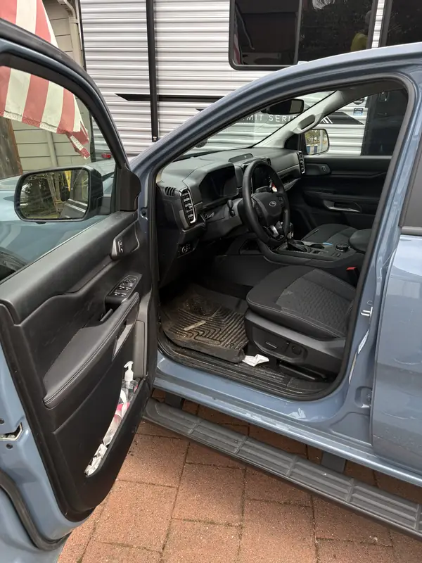 Ford Ranger front seat and floor before, with a muddy mat